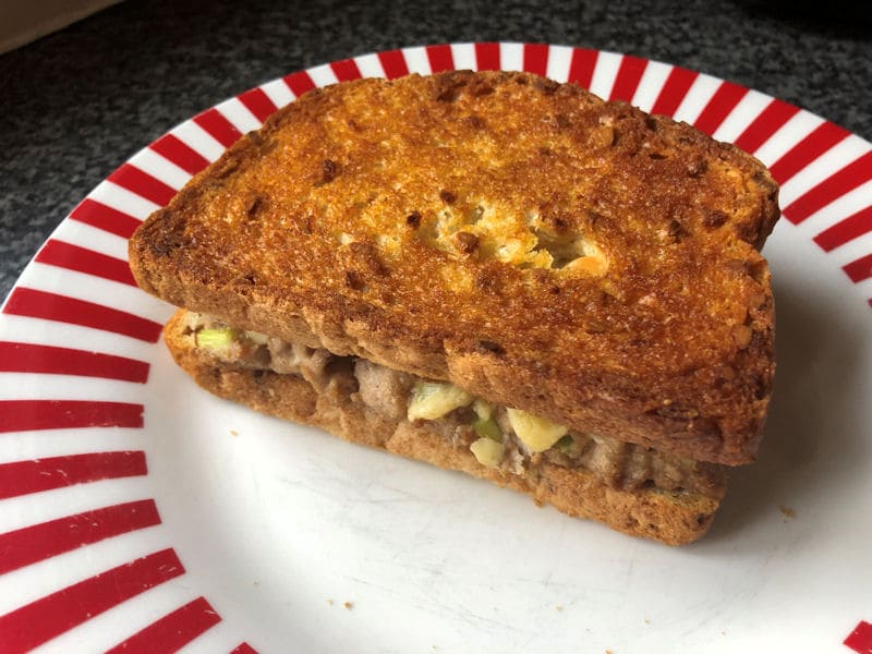 Toasted tuna melt sandwich served on small ceramic plate