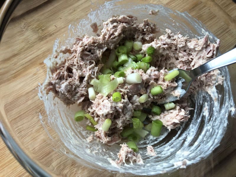 Mixing freshly chopped spring onion into tuna and mayonnaise spread